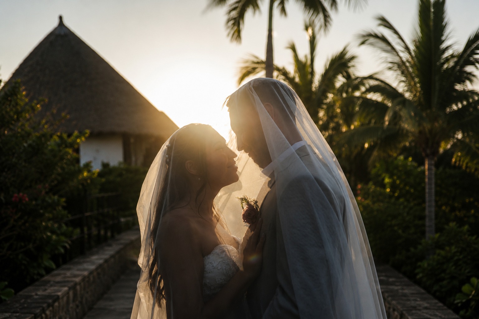 Bride and groom embracing by the sea, cinematic light